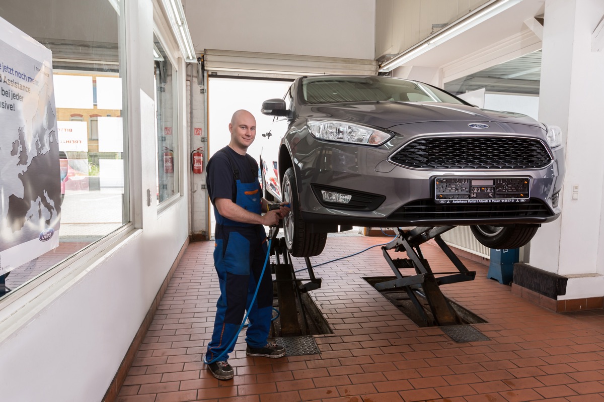 Fahrzeuginstandhaltung bei Autohaus Voitel: Mechaniker an einem Ford auf der Hebebühne in der Werkstatt Plauen